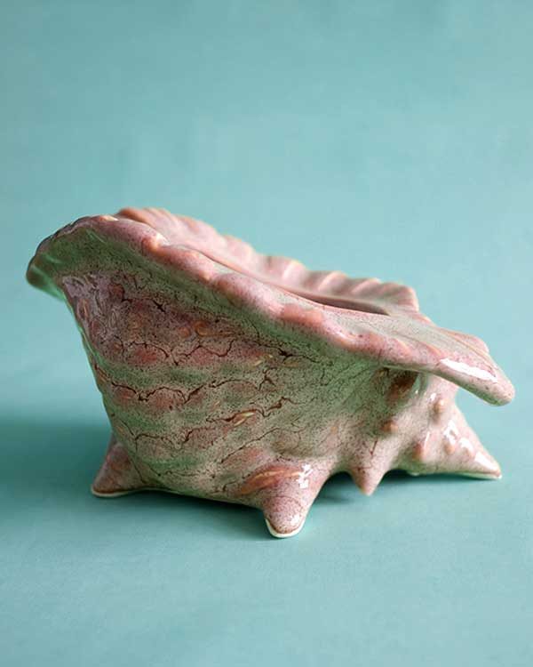 Ceramic Tiki mug in the shape of a conch shell.