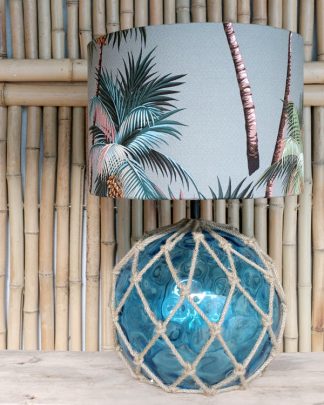 Tropical print table lampshade against bamboo wall