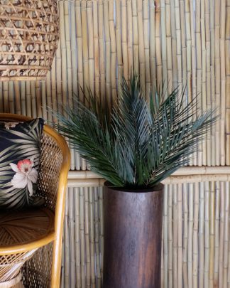 Picture of preserved palm frons in a arran pot in a tiki room setting with bamboo clad walls and rattan furniture